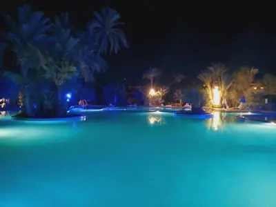 a swimming pool at night with blue lights at L'Oasis Chic Palmeraie Marrakech Piscine & Petit Déj Offert in Marrakech