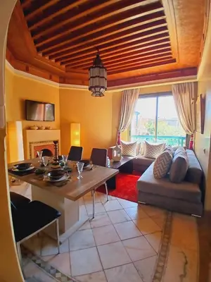 a living room with a table and a couch at L'Oasis Chic Palmeraie Marrakech Piscine & Petit Déj Offert in Marrakech