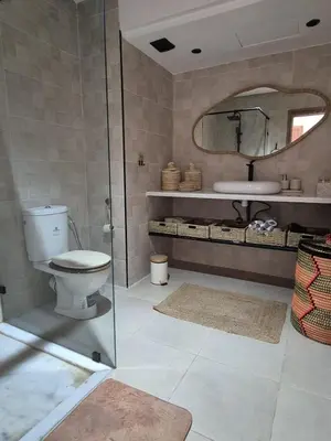a bathroom with a toilet and a sink and a mirror at Sumptuous apartment in Premium Village in Marrakech