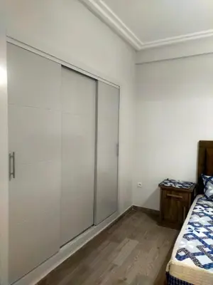 a bedroom with a sliding glass door next to a bed at 2-bedroom apartment in Marrakech