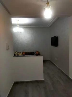 an empty room with a table and a television at 2-bedroom apartment in Marrakech