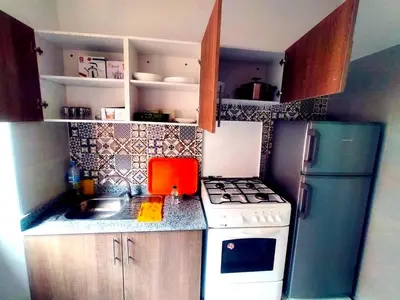 a small kitchen with a stove and a refrigerator at 2-bedroom apartment in Marrakech
