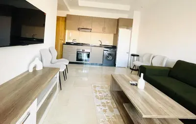 a living room with a green couch and a table at Cozy appartement à noria golf in Marrakech