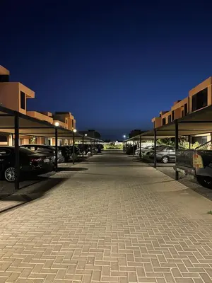 a parking lot with cars parked in front of buildings at Cozy appartement à noria golf in Marrakech