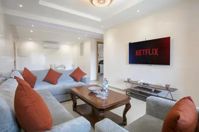 a living room with a couch and a tv at The Comfort Zone - Private Pool in Marrakech