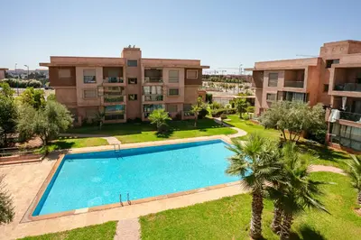 an apartment with a swimming pool in front of a building at The Comfort Zone - Private Pool in Marrakech