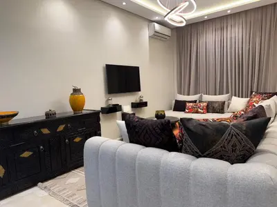 a living room with a couch and a tv at Marrakech Apartment Hivernage in Marrakech