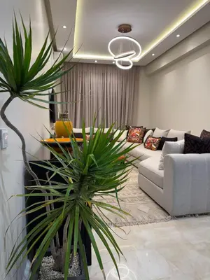 a living room with a couch and two palm trees at Marrakech Apartment Hivernage in Marrakech