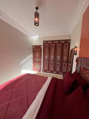 a bedroom with a large bed and wooden doors at Marrakech Apartment Hivernage in Marrakech