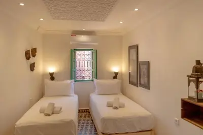 two twin beds in a room with a window at Riad Dar Moulay 120m2 in der Medina mit Terrasse in Marrakech