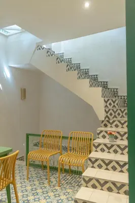two chairs and a staircase in a room at Riad Dar Moulay 120m2 in der Medina mit Terrasse in Marrakech