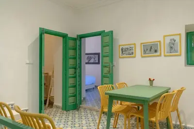 a dining room with a green table and chairs at Riad Dar Moulay 120m2 in der Medina mit Terrasse in Marrakech