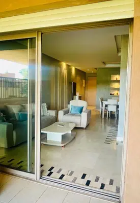 a living room with a couch and a table at Superb apartment with all amenities and pool in Marrakech