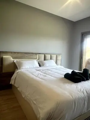 a bedroom with a large white bed with a window at Superb apartment with all amenities and pool in Marrakech