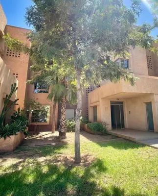 a palm tree in front of a building at Superb apartment with all amenities and pool in Marrakech