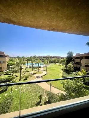 a view of a park from a window at Superb apartment with all amenities and pool in Marrakech