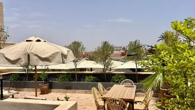 a table and chairs with an umbrella on a patio at Riad Bergamot in Marrakech
