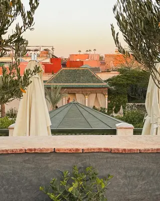 a view of a building from a garden with umbrellas at Riad Bergamot in Marrakech
