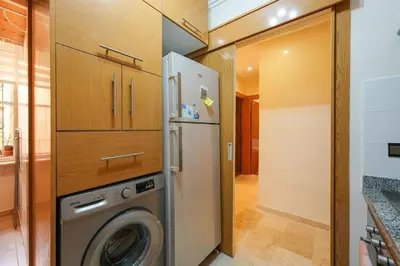 a kitchen with a washer and dryer next to a refrigerator at NS 51 by KMREI Properties in Marrakech