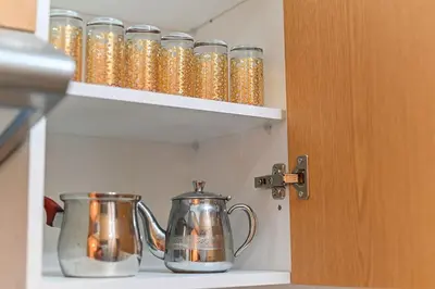 a kitchen cabinet with two tea pots on a shelf at NS 51 by KMREI Properties in Marrakech