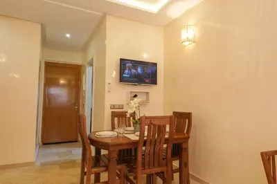 a dining room with a table and a tv on the wall at NS 51 by KMREI Properties in Marrakech