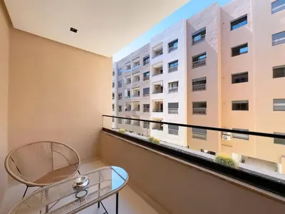 a balcony with a table and a building at Menara Garden Wifi Parking Piscine in Marrakech
