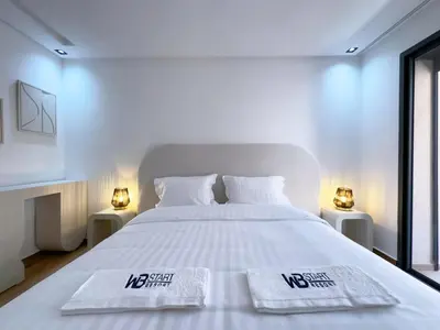 a bedroom with a large white bed with two lamps at Menara Garden Wifi Parking Piscine in Marrakech