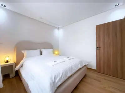 a bedroom with a large white bed and a wooden cabinet at Menara Garden Wifi Parking Piscine in Marrakech