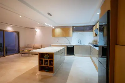 a kitchen with white cabinets and a table in it at Villa Akenza - Cinema - Swiming pool in Marrakech