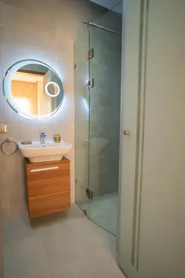 a bathroom with a sink and a shower with a mirror at Villa Akenza - Cinema - Swiming pool in Marrakech