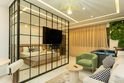 a living room with a couch and a tv at Luxurious apartment ,hot tub in Marrakech