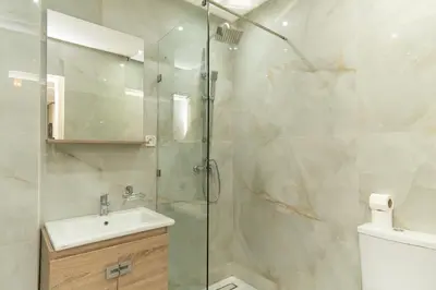 a bathroom with a shower with a sink and a toilet at Luxurious apartment ,hot tub in Marrakech