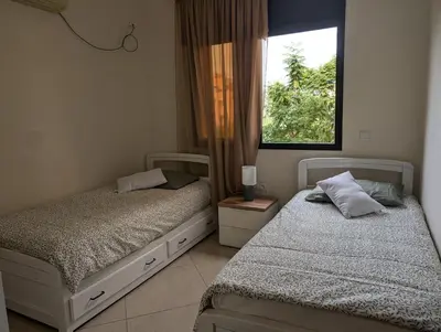 two beds in a bedroom with a window at Le Cocon Nature in Marrakech