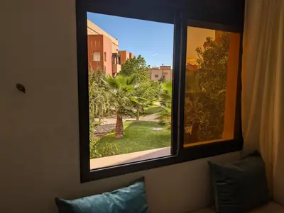 a view of a palm tree from a window at Le Cocon Nature in Marrakech