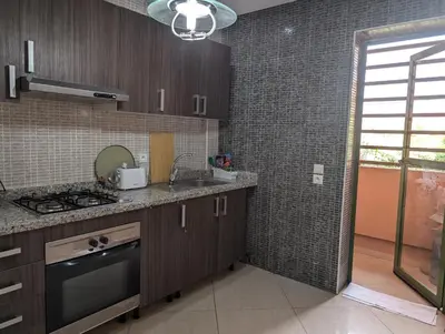 a kitchen with brown cabinets and a sink and a window at Le Cocon Nature in Marrakech
