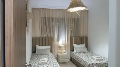 a bedroom with two beds and a mirror at Two bedroom apartment - Guéliz train station in Marrakech