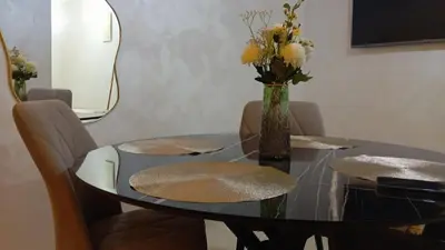 a glass table with a vase with flowers on it at Two bedroom apartment - Guéliz train station in Marrakech