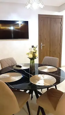 a dining room with a black table and chairs at Two bedroom apartment - Guéliz train station in Marrakech