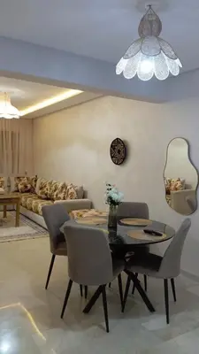 a living room with a table and chairs and a couch at Two bedroom apartment - Guéliz train station in Marrakech