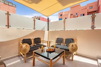 a patio with chairs and a table on a balcony at NOUVEAU à Marrakech in Marrakech