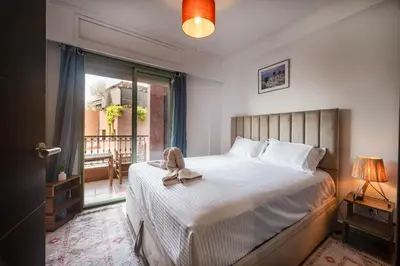 a bedroom with a bed with a stuffed animal on it at Studio cosy avec piscine et balcon Résidence Mirador Majorelle in Marrakech
