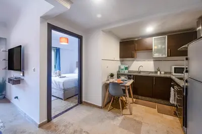 a kitchen with a table and a bed in a room at Studio cosy avec piscine et balcon Résidence Mirador Majorelle in Marrakech