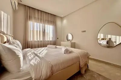 a bedroom with a large bed and a mirror at Top floor apartment in Gueliz with Balcony in Marrakech