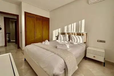 a bedroom with a large bed with white sheets and pillows at Top floor apartment in Gueliz with Balcony in Marrakech