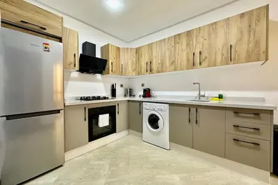 a kitchen with wooden cabinets and a washer and dryer at Top floor apartment in Gueliz with Balcony in Marrakech