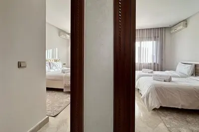 a view of a bedroom with two beds and a mirror at Top floor apartment in Gueliz with Balcony in Marrakech