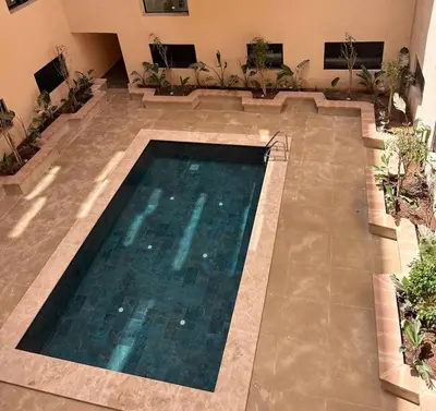 an empty swimming pool in a building with plants at Marrakech Éternel - Hivernage in Marrakech
