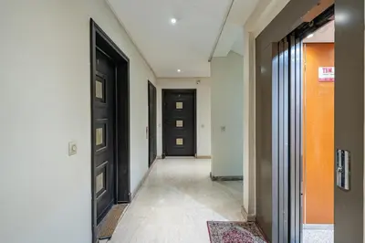 an empty hallway with black doors and a rug at Marrakech GUELIZ Vue Imprenable et Terrasse rare in Marrakech