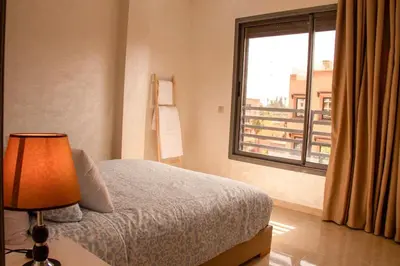a bedroom with a bed and a large window at Regine in Marrakech