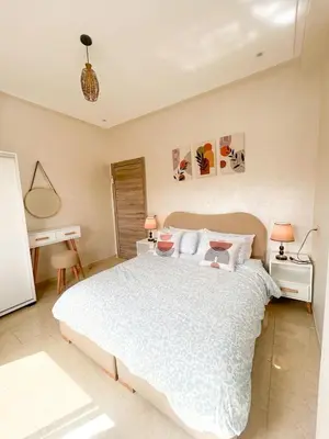 a bedroom with a large white bed and a desk at Regine in Marrakech
